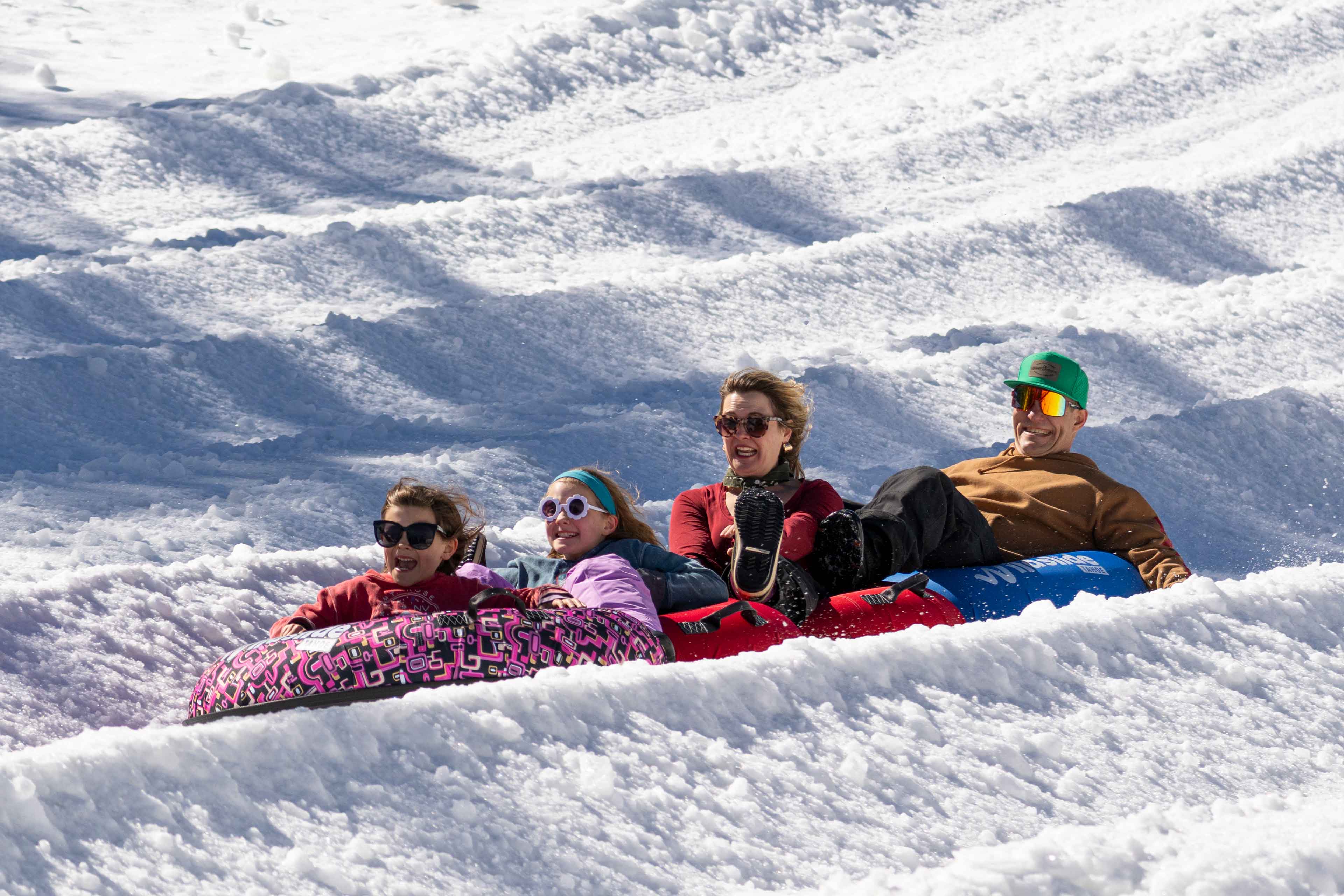 family sliding down in tubes at wildslide winter park